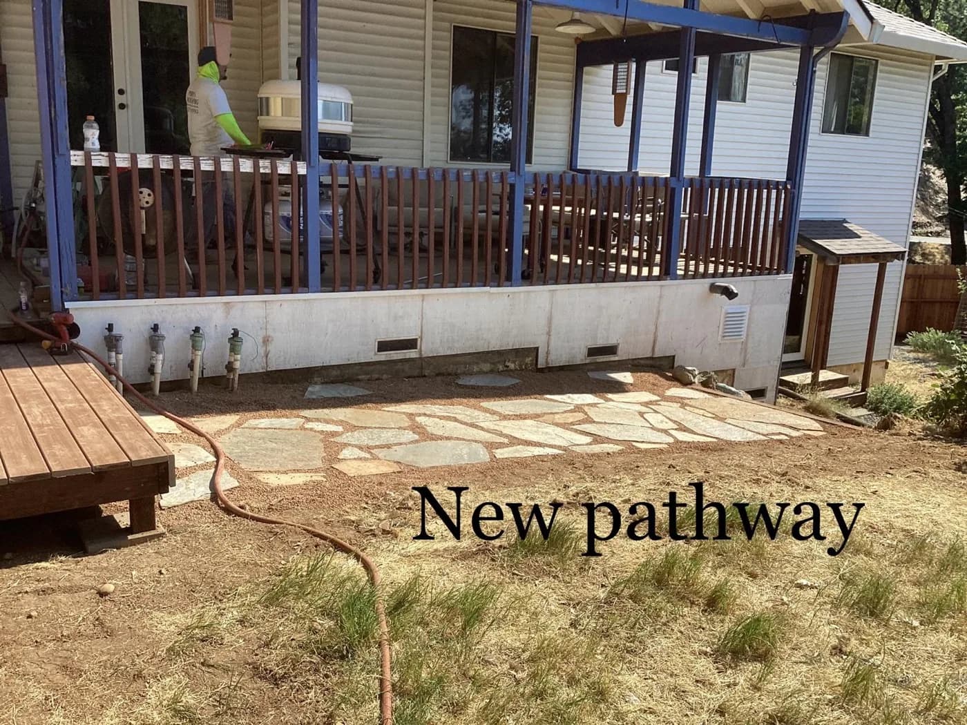 Flagstone patio newly laid beside a covered porch and painted deck