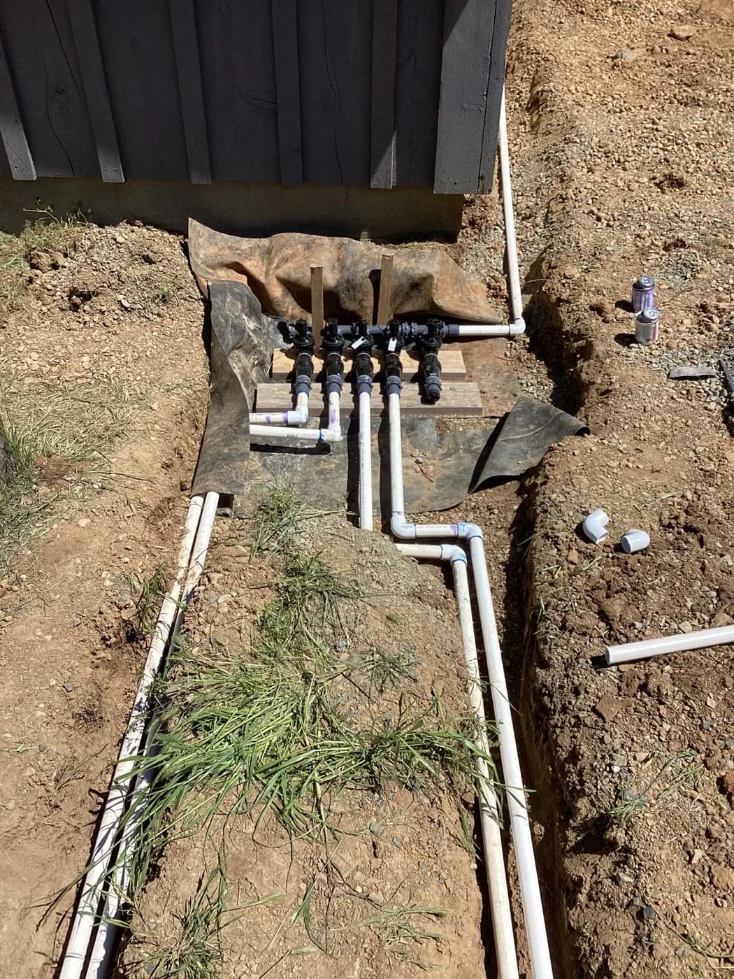 Sprinkler valve manifold set into a trench before backfilling