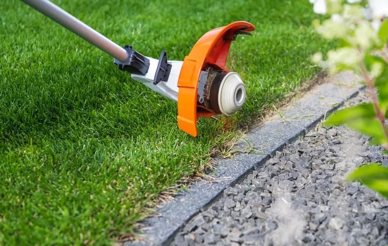 String trimmer cutting a clean edge along a lawn